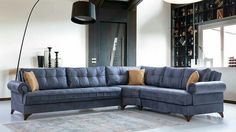 a living room with a blue sectional couch and large floor lamp in the corner next to it