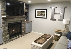 a living room filled with furniture and a flat screen tv mounted on the wall above a fireplace