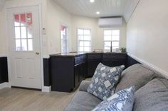 a living room filled with furniture next to a kitchen