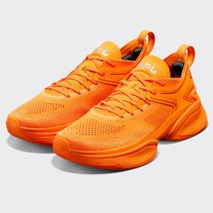 an orange pair of sneakers on a white background