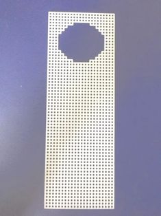 a white cell phone case sitting on top of a blue surface with holes in it