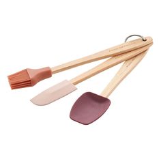 three wooden utensils and one spatula are on a white surface with a pink handle