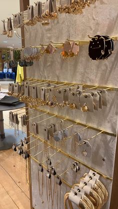 a display case filled with lots of gold and silver jewelry hanging from it's sides