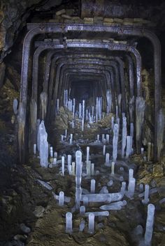 the inside of a cave filled with lots of white rocks and cement pillars, all lined up in rows