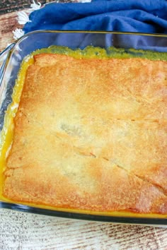 a casserole in a glass dish on a wooden table with a blue cloth