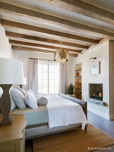 a bedroom with a bed and fireplace in it's center area, surrounded by wooden beams