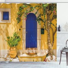 a yellow house with blue door and potted plants on the outside wall shower curtain set