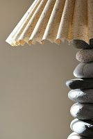 a lamp that is sitting on top of some kind of rock stacked with rocks and sand