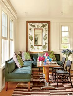 a living room with green couches and striped rugs on the wooden flooring