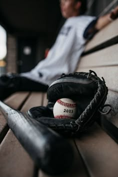 a baseball glove and ball sitting on top of a bench