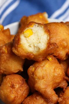 some fried food on a white plate with a blue and white striped table cloth in the background