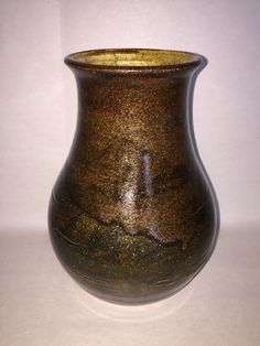 a brown vase sitting on top of a white table