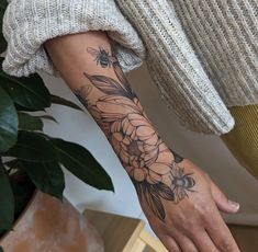 a woman's arm with flowers on it and a bee sitting on the flower