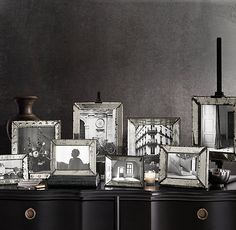 a black dresser topped with pictures and candles