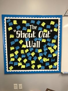 there is a sign on the wall that says, the short out wall with yellow and blue blocks