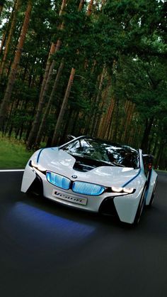 a white car driving down a road next to trees