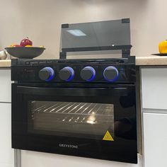 the oven is built into the wall in the kitchen, and has blue lights on it