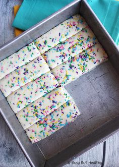 sprinkles and white frosting in a pan