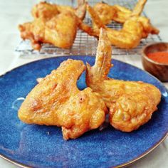 fried chicken wings on a blue plate with dipping sauce