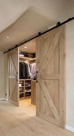 an open closet with sliding doors and wooden floors