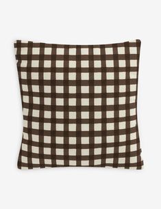 a brown and white checkered pillow on a white background