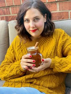 a woman sitting on a couch holding a jar of peanut butter