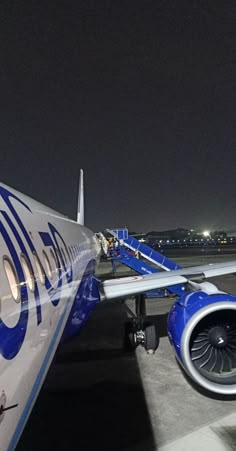 an airplane is parked on the tarmac at night with its lights on and it's wheels down