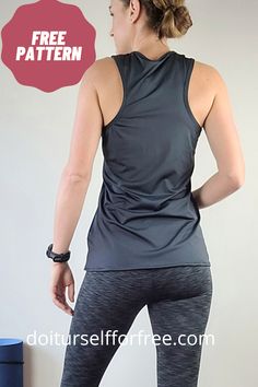 a woman in black top and grey leggings standing up with her back to the camera