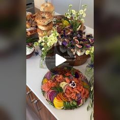 a table topped with lots of food on top of a white counter covered in flowers