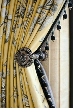 an image of curtains with beaded trims and draperies on the window sill