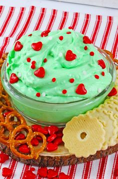 a green dip surrounded by pretzels and crackers