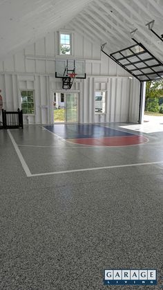 an indoor basketball court is shown in this image with the garage door open to allow for people to play