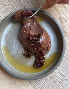 a person is scooping chocolate ice cream into a bowl with granola on top