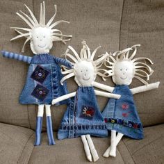 three little dolls made out of jeans are sitting on a couch with their arms in the air