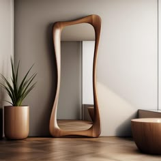 a mirror sitting on top of a wooden floor next to a plant in a vase