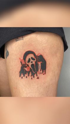 a person with a black and red tattoo on their thigh, holding a knife in his hand