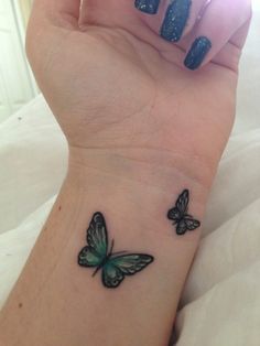 a woman's wrist tattoo with two butterflies on the left side of her arm