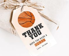 a thank you card with a basketball on it is tied to a white gift bag