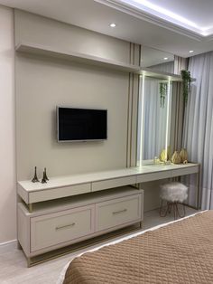 a bed room with a neatly made bed and a flat screen tv on the wall