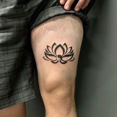 a man with a tattoo on his leg that has a lotus flower in the center