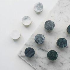 marble and metal buttons sitting on top of a white table