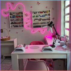 a desk with a pink light in the corner and shelves on the wall behind it