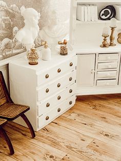 a white dresser sitting next to a wooden chair