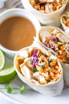 several burritos on a plate with dipping sauce