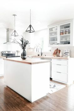 a kitchen with white cabinets and wooden floors is seen in this image from the front view