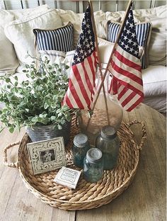 an american flag is on the coffee table in front of a couch with two flags