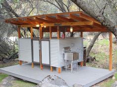 a small outdoor kitchen in the middle of some trees