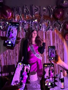 a woman in a purple dress holding up two cell phones