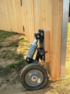 a wheel attached to the side of a wooden fence