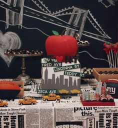 a table topped with lots of different types of cakes and pastries next to a chalkboard